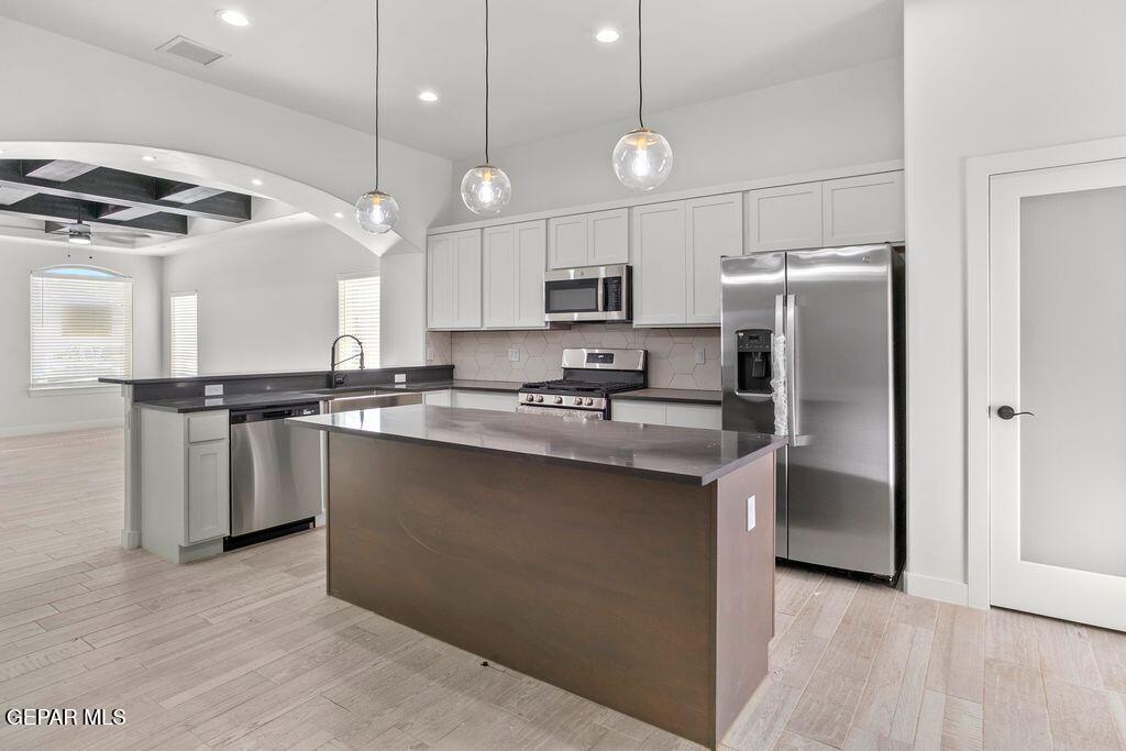 3761 Course Street El Paso, TX 79938 - Photo 14 of 15 a kitchen with stainless steel appliances granite countertop a refrigerator a sink dishwasher a stove and a refrigerator with wooden floor