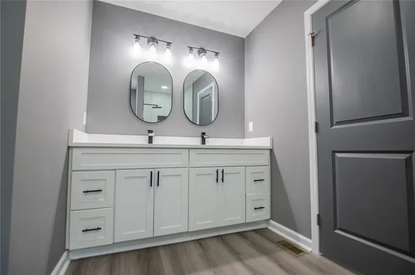 an empty room with wooden floor and ceiling fan