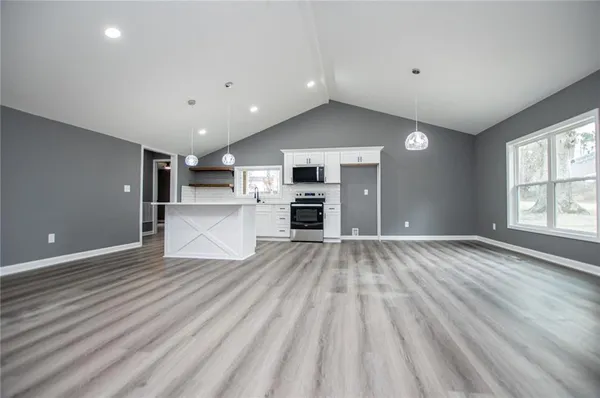 an empty room with windows and wooden floor