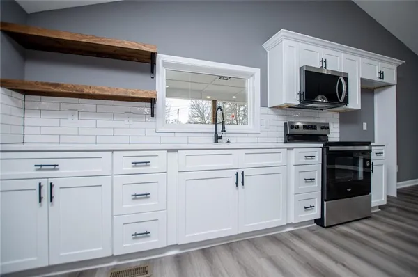 a kitchen with white cabinets and appliances