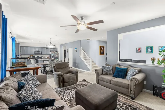 a view of a dining room with furniture a kitchen and chandelier