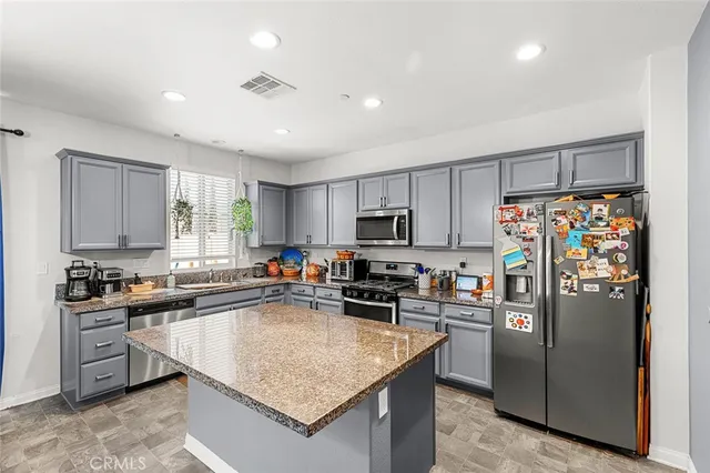 a kitchen with granite countertop a sink counter top space appliances and cabinets