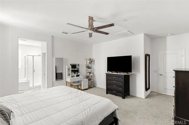 a bedroom with a bed and a flat tv screen on dresser