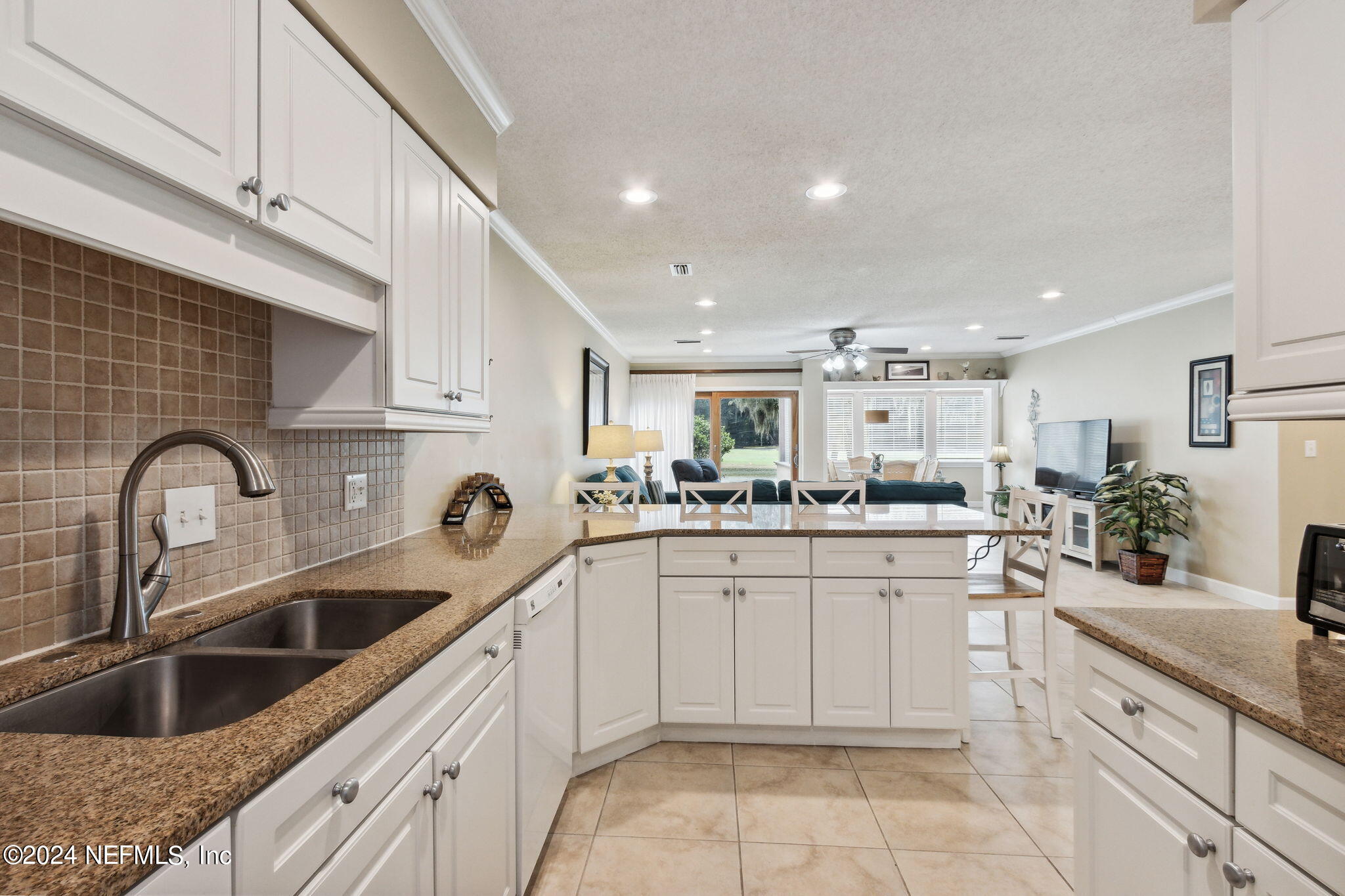 3327 Sea Marsh Road Fernandina Beach, FL 32034 - Photo 9 of 39 a kitchen with white cabinets a sink and dishwasher