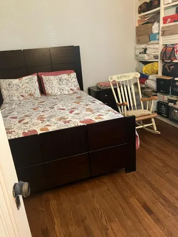 a bedroom with a bed and wooden floor