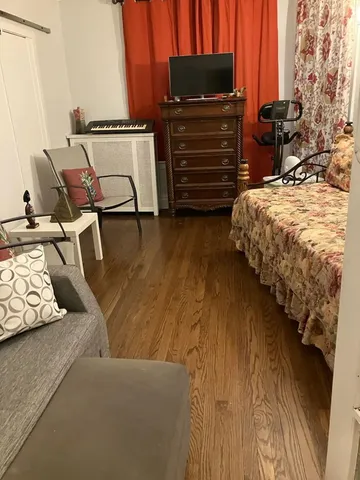 a bedroom with a bed and wooden floor