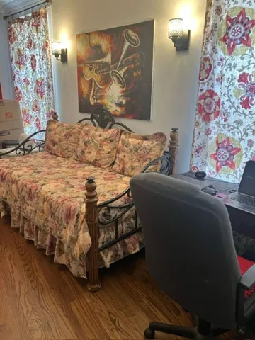 a bedroom with a bed and painting on the wall