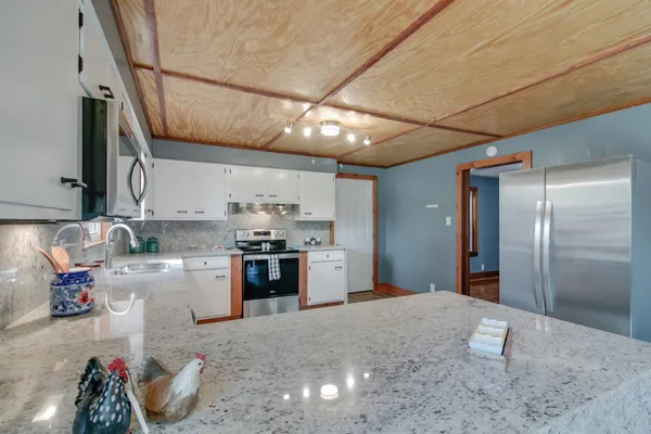 a kitchen with stainless steel appliances granite countertop a sink a stove and a refrigerator