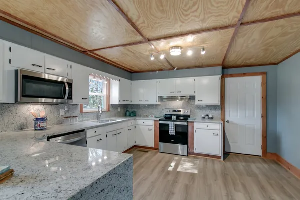 a large kitchen with a lot of counter space and a wooden floor