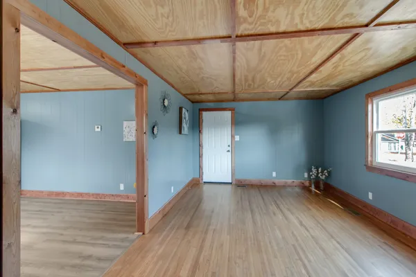 a view of a room with wooden floor and a ceiling fan