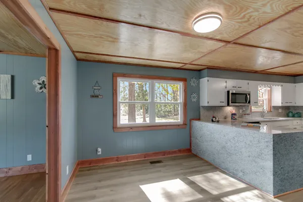 a kitchen with granite countertop a sink window and cabinets