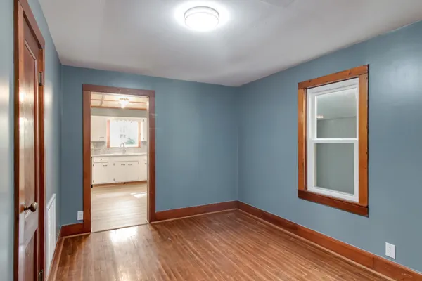 a view of empty room with wooden floor