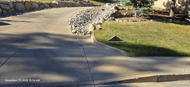 a sign board with a house and trees in the background