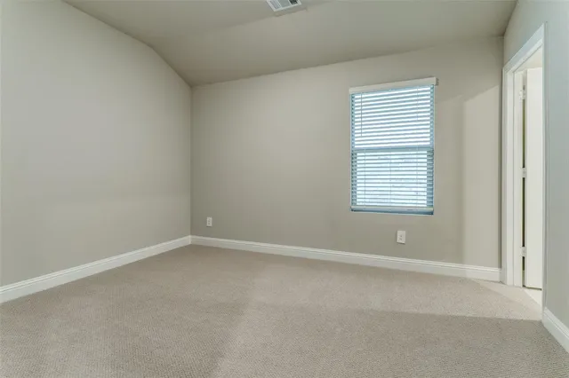 an empty room with closet and a bathroom