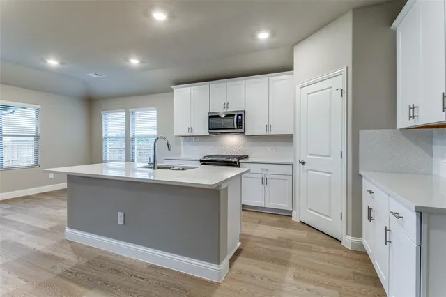 a kitchen with stainless steel appliances granite countertop a sink stove and cabinets
