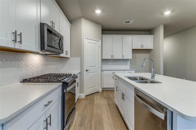a view of a kitchen with a sink cabinets wooden floor and a window