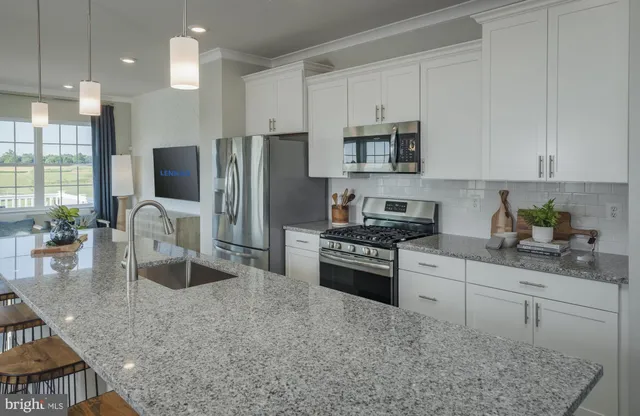 a kitchen with stainless steel appliances granite countertop a stove refrigerator sink and cabinets