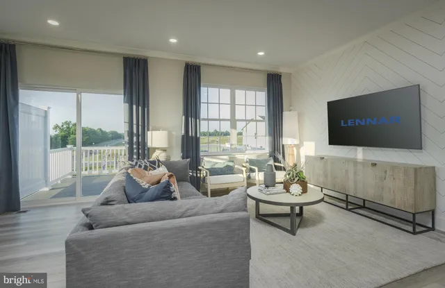 a living room with furniture a flat screen tv and a floor to ceiling window
