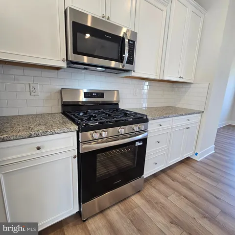 a kitchen with stainless steel appliances granite countertop a stove microwave and sink