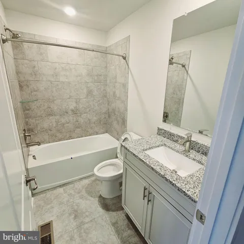 a bathroom with a granite countertop sink toilet a mirror and shower