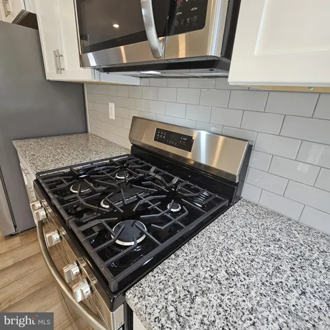 a stove sitting inside of a kitchen with white cabinets