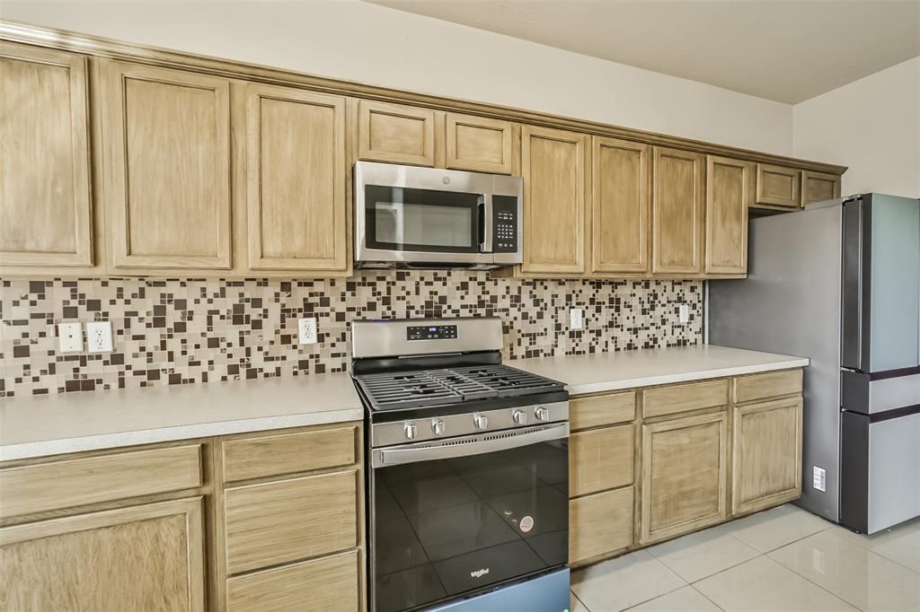 911 Merlin Roost Katy, TX 77494 - Photo 13 of 42 a kitchen with granite countertop cabinets and steel stainless steel appliances