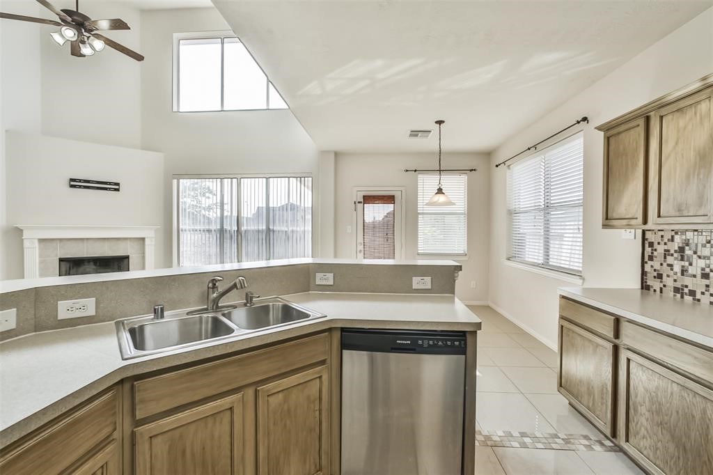 911 Merlin Roost Katy, TX 77494 - Photo 15 of 42 a kitchen with stainless steel appliances granite countertop a sink a stove and a granite counter tops with white cabinets