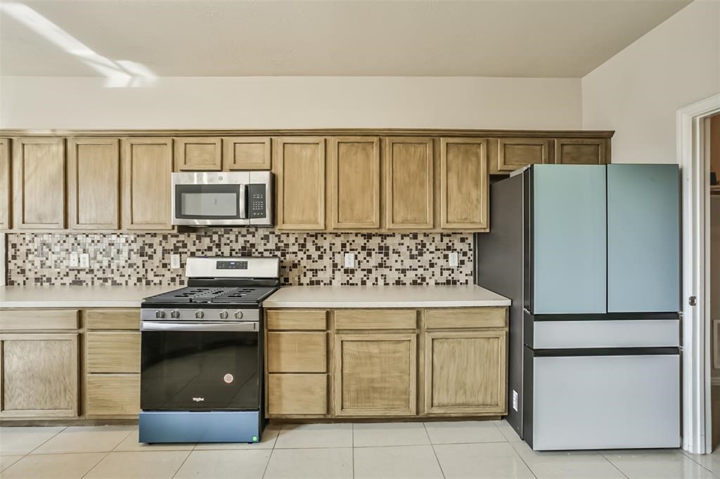 911 Merlin Roost Katy, TX 77494 - Photo 16 of 42 a kitchen with a stove and a refrigerator
