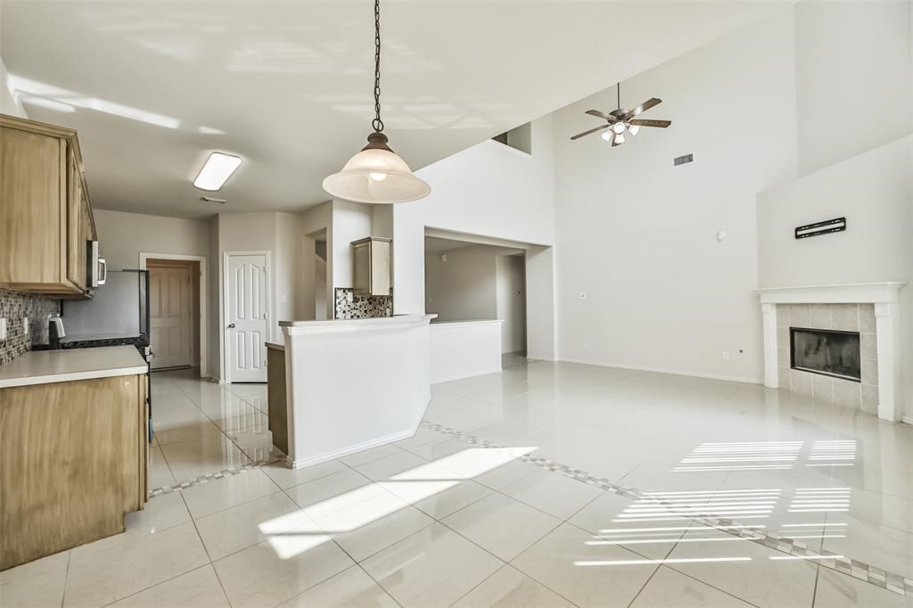 911 Merlin Roost Katy, TX 77494 - Photo 18 of 42 a view of a kitchen with a sink a refrigerator and a fireplace