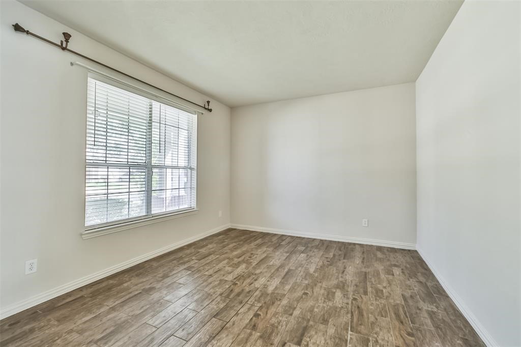 911 Merlin Roost Katy, TX 77494 - Photo 22 of 42 an empty room with wooden floor and windows