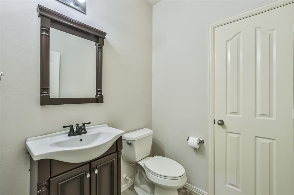 911 Merlin Roost Katy, TX 77494 - Photo 24 of 42 a bathroom with a toilet a sink and mirror