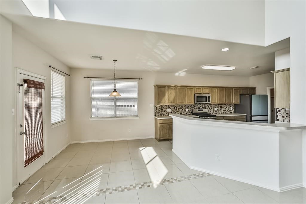 911 Merlin Roost Katy, TX 77494 - Photo 10 of 42 a kitchen with stainless steel appliances granite countertop a stove a sink and a refrigerator