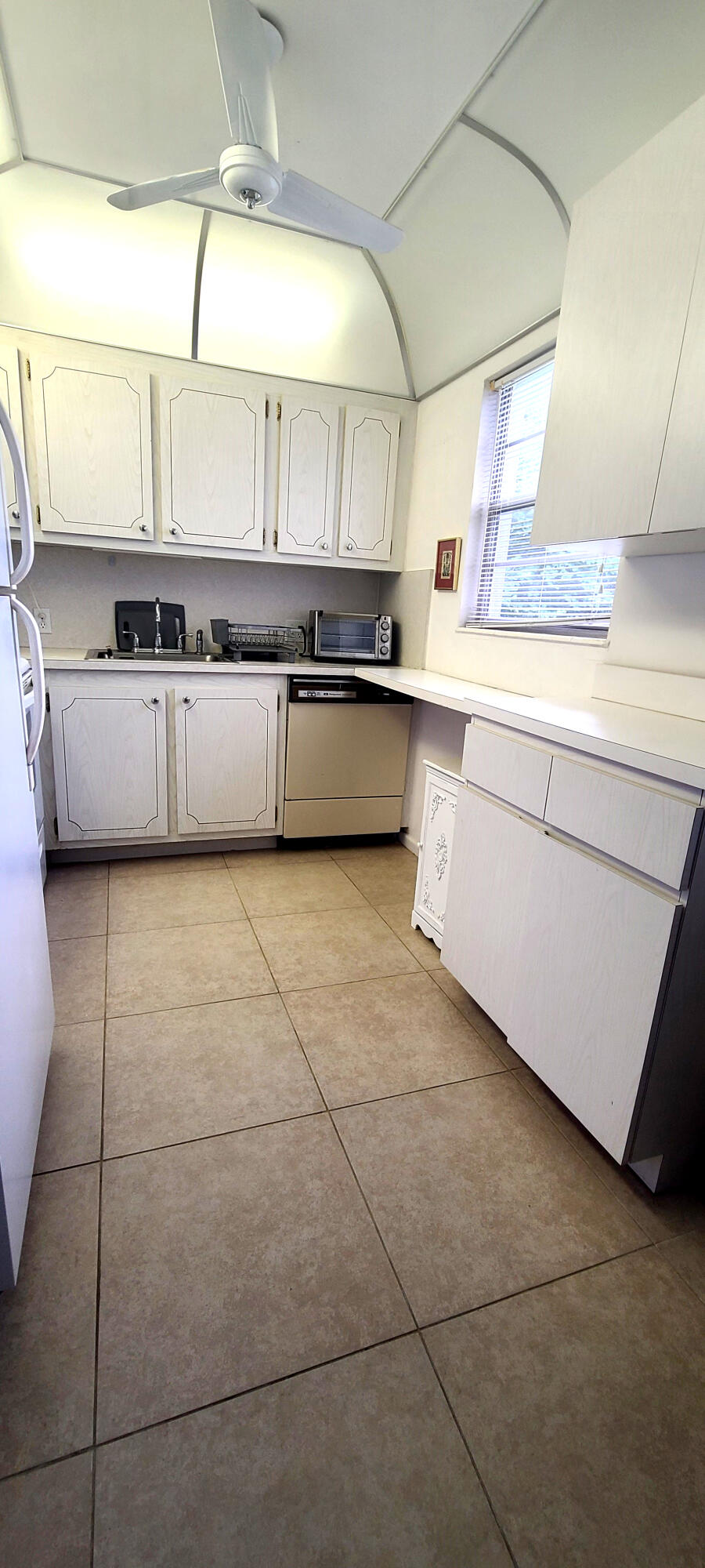 270 Suffolk F Boca Raton, FL 33434 - Photo 14 of 21 a large kitchen with a large counter top a sink a stove and cabinets