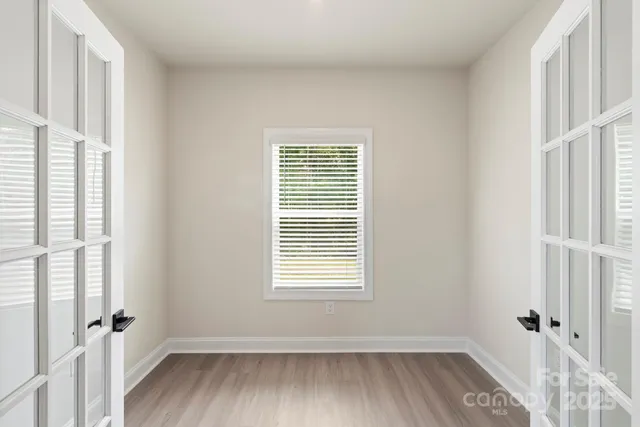 a view of a room with wooden floor and window