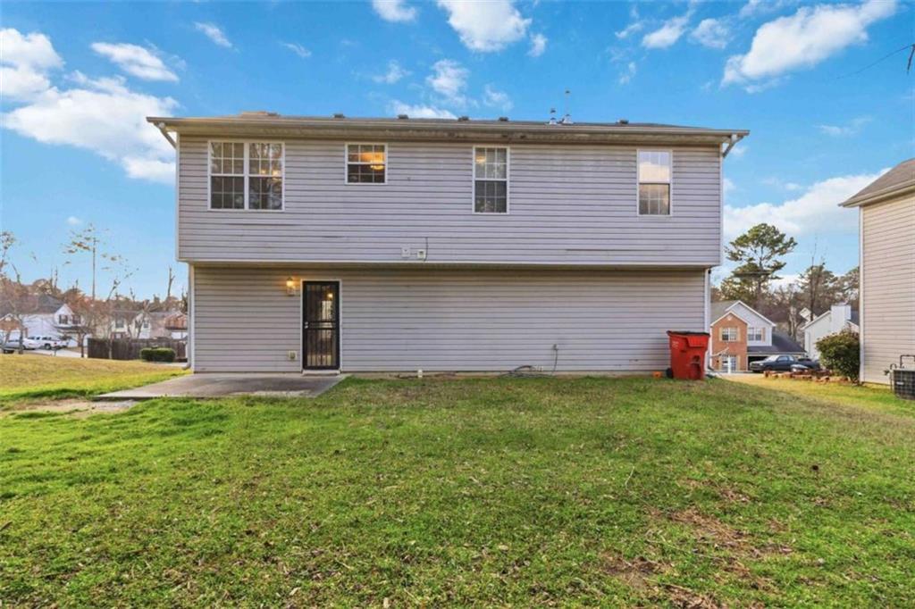 4170 Jewel Terrace Conley, GA 30288 - Photo 26 of 29 a front view of a house with a yard and garage