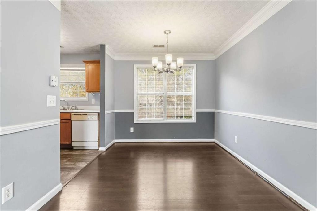 4170 Jewel Terrace Conley, GA 30288 - Photo 7 of 29 an empty room with wooden floor chandelier and windows