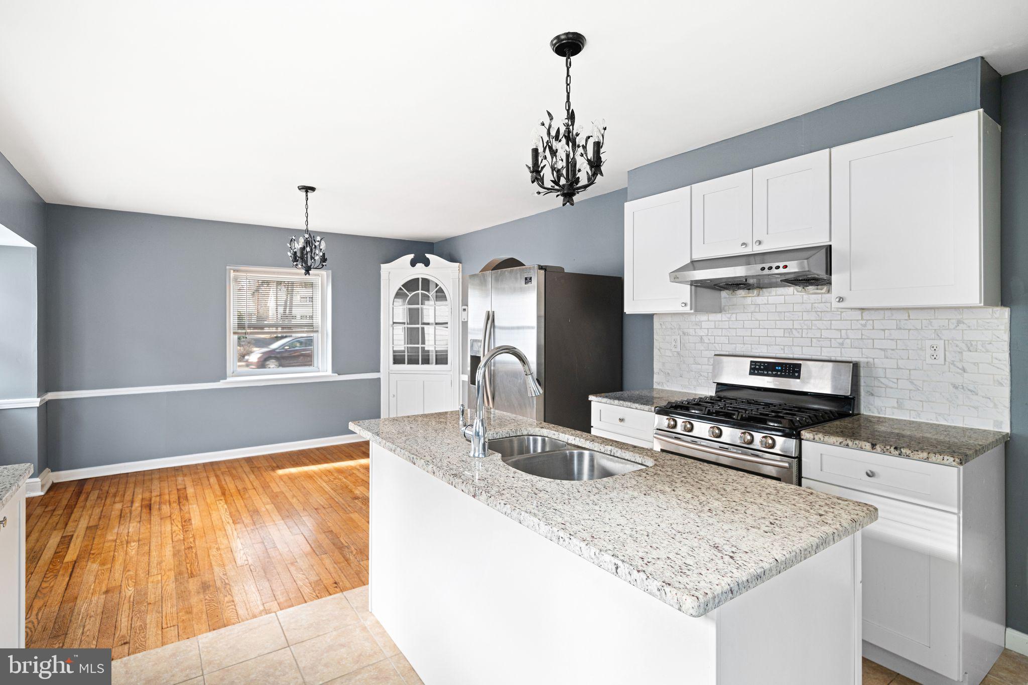 4310 State Road Drexel Hill, PA 19026 - Photo 9 of 24 a kitchen with stainless steel appliances granite countertop a sink dishwasher and a stove with wooden floor
