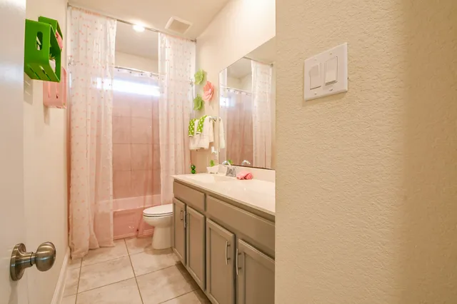 a spacious bathroom with a granite countertop sink a mirror and a shower