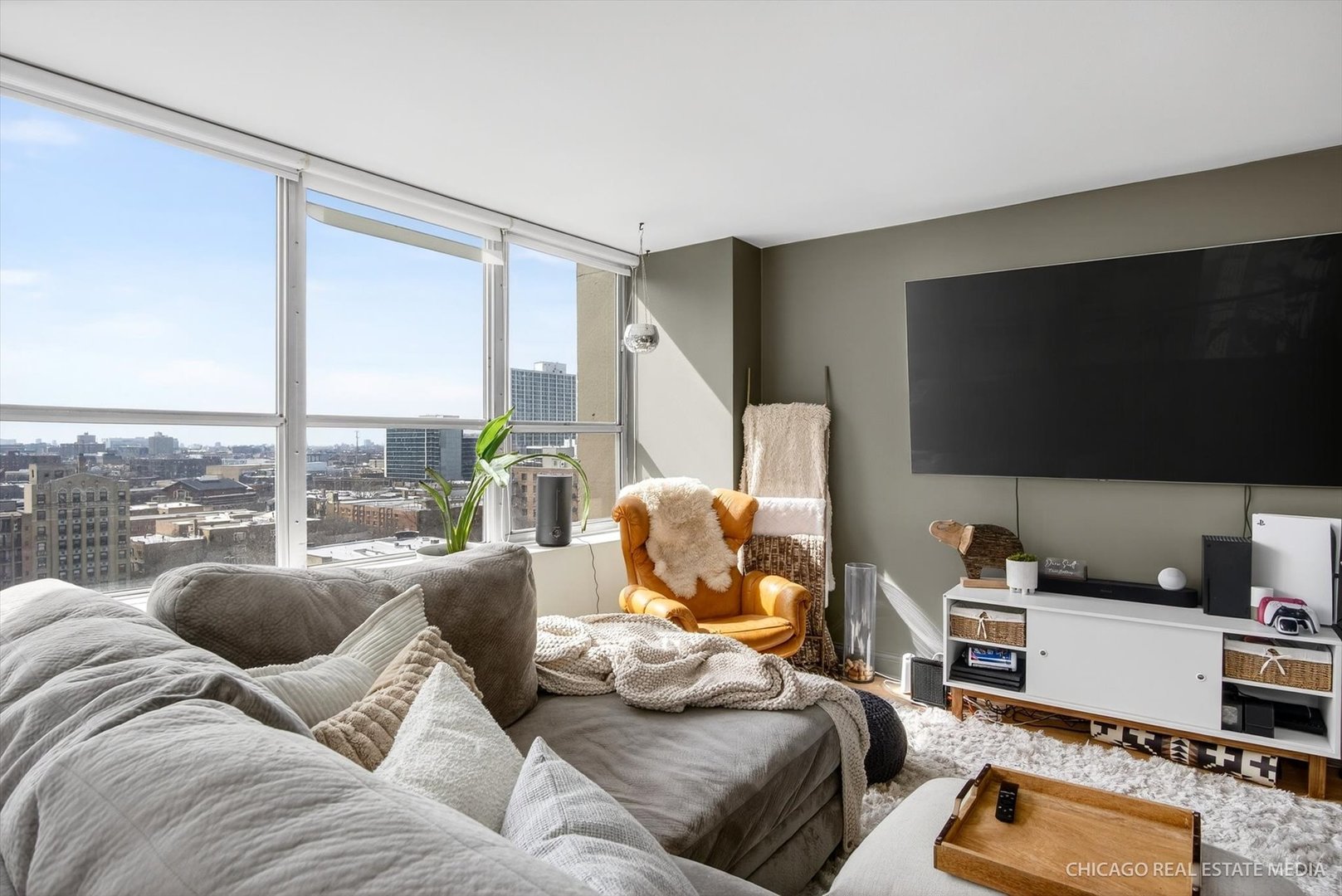 655 West Irving Park Road, Unit 1101 Chicago, IL 60613 - Photo 7 of 26 a living room with furniture a flat screen tv and a floor to ceiling window