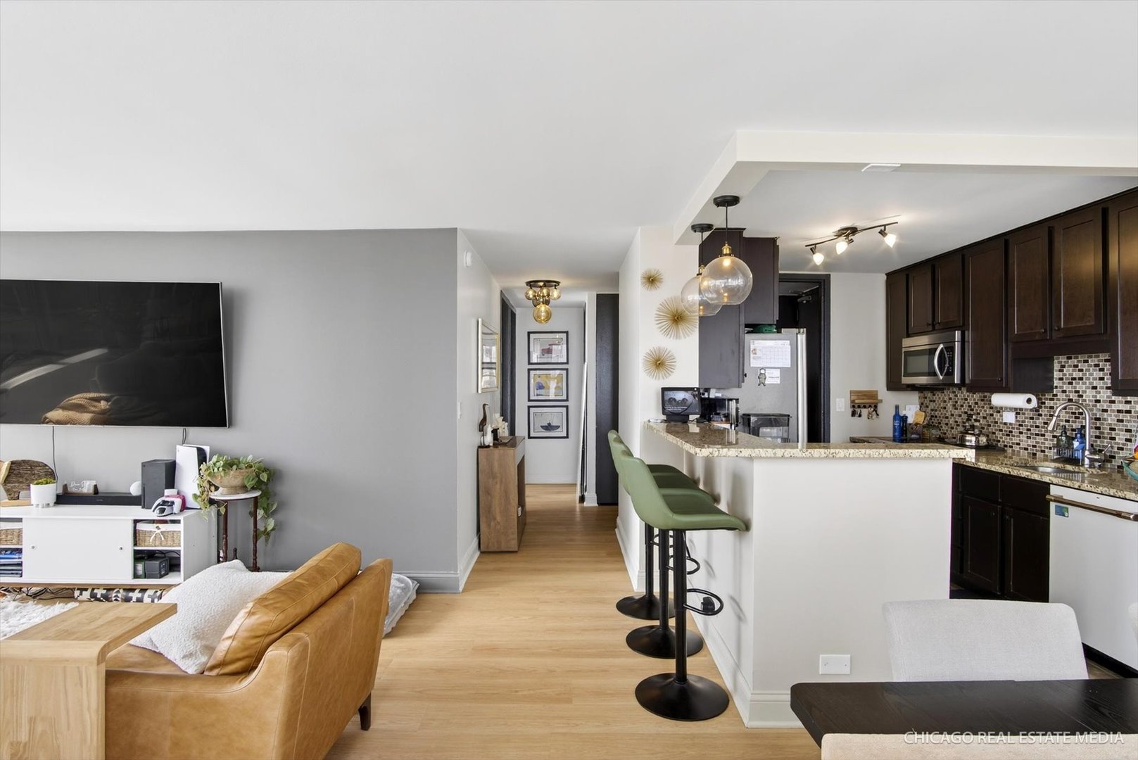 655 West Irving Park Road, Unit 1101 Chicago, IL 60613 - Photo 9 of 26 a kitchen with a table chairs refrigerator and microwave