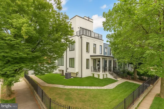 a front view of a house with a yard and trees