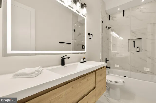 a bathroom with a sink a toilet and shower