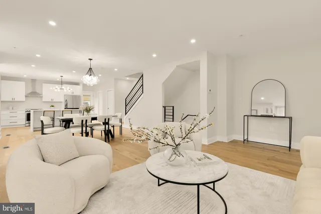 a living room with furniture a table and kitchen view