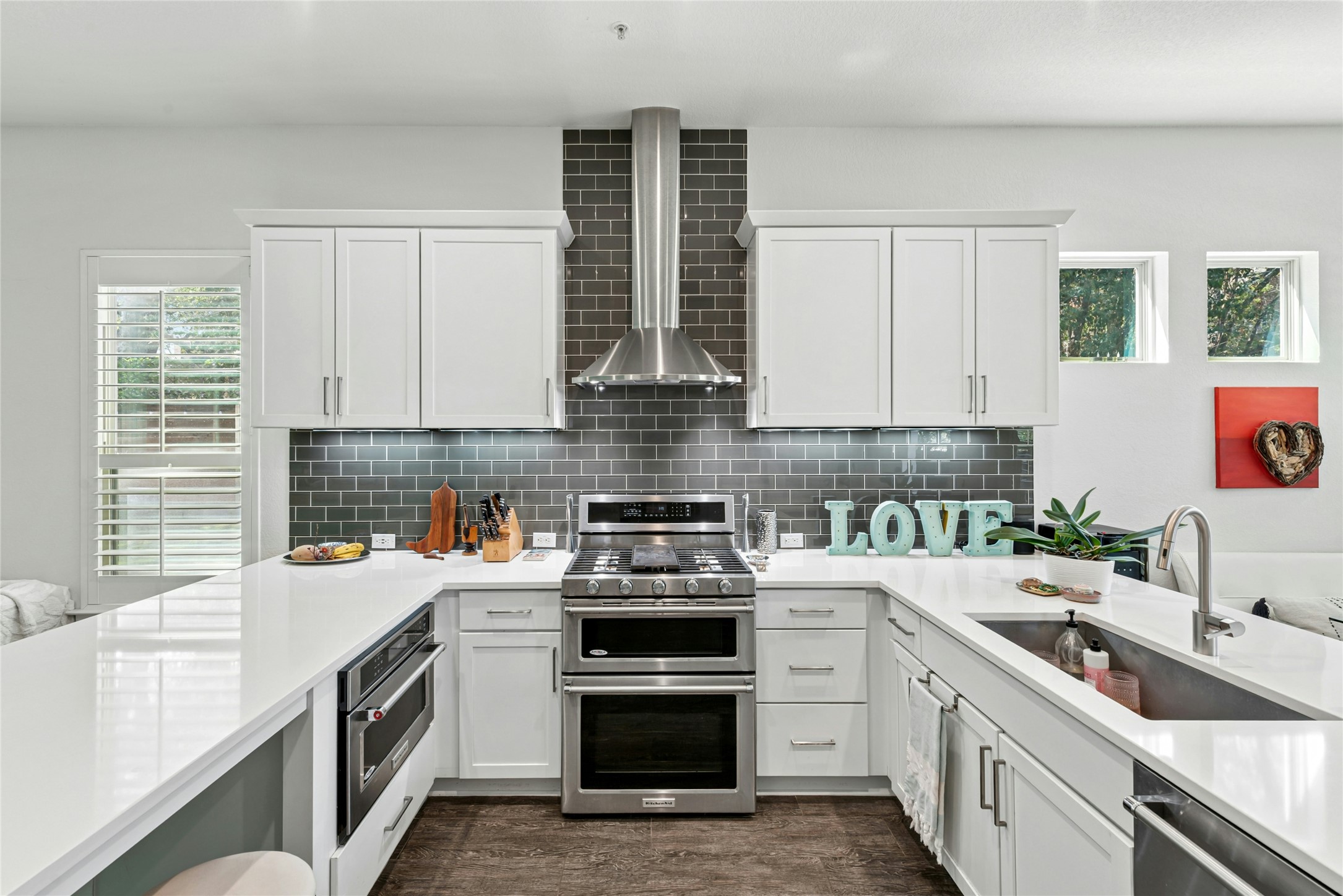 404 West Alpine Road, Unit 17 Austin, TX 78704 - Photo 14 of 35 Kitchen featuring a peninsula, stainless steel appliances, white cabinets, light stone countertops, and backsplash