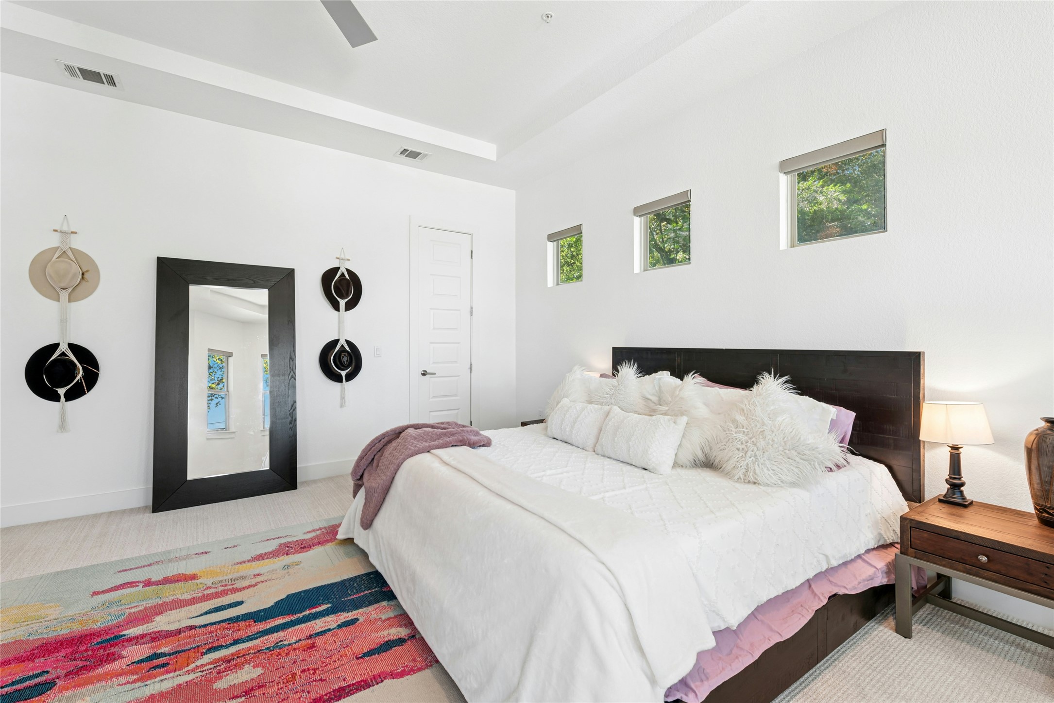404 West Alpine Road, Unit 17 Austin, TX 78704 - Photo 25 of 35 Bedroom featuring light carpet, a ceiling fan, and a raised ceiling
