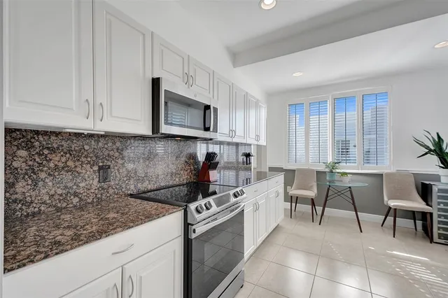 a kitchen with granite countertop a sink stove and cabinets