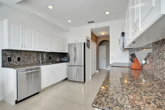 a kitchen with refrigerator and cabinets