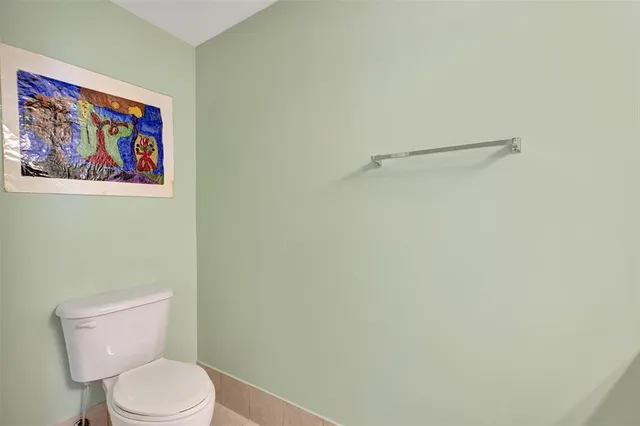 a white toilet sitting next to a shower