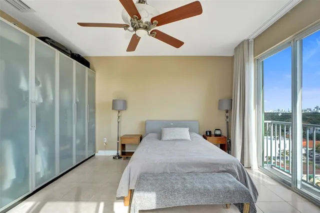 a bedroom with a large bed and a chandelier