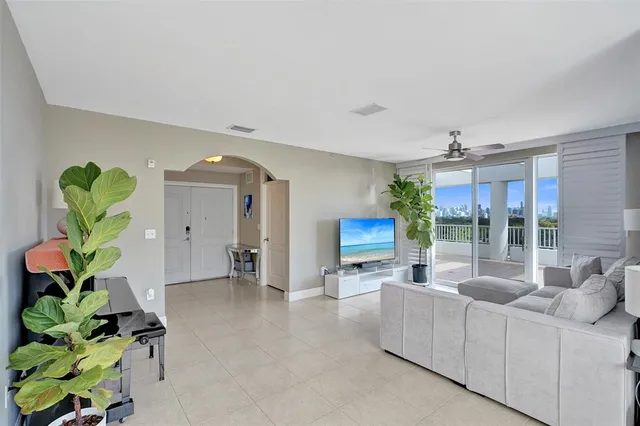 a living room with furniture a chandelier and a potted plant